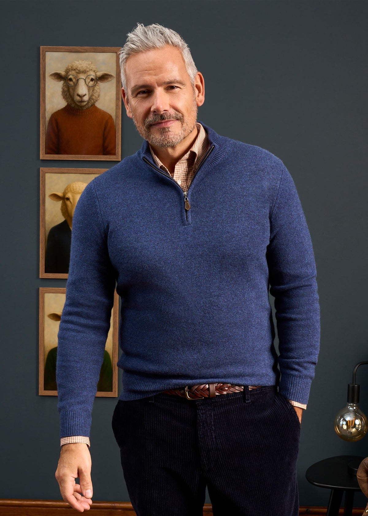A man wearing a Sutherland Lambswool Quarter Zip Jumper In Rhapsody over a checkered shirt.