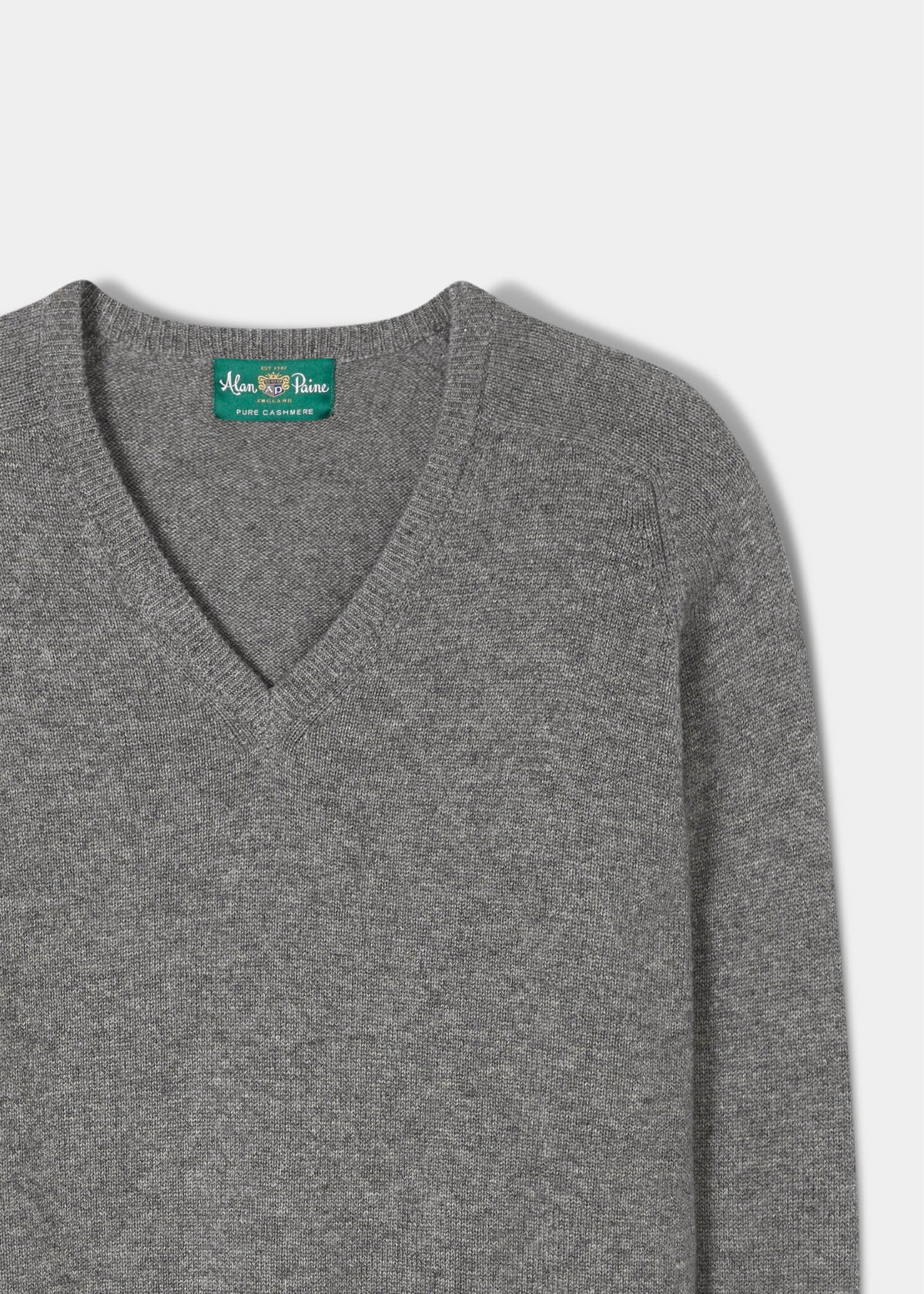 Selkirk Pure Cashmere V-Neck Jumper In Derby: grey cashmere v-neck with a branded green label at the inner neckline.