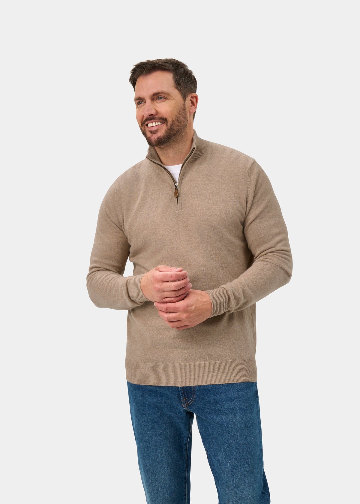 Smiling man wears Hanbury Pure Cashmere Quarter Zip Jumper in Linen, regular fit, and blue jeans on white background.