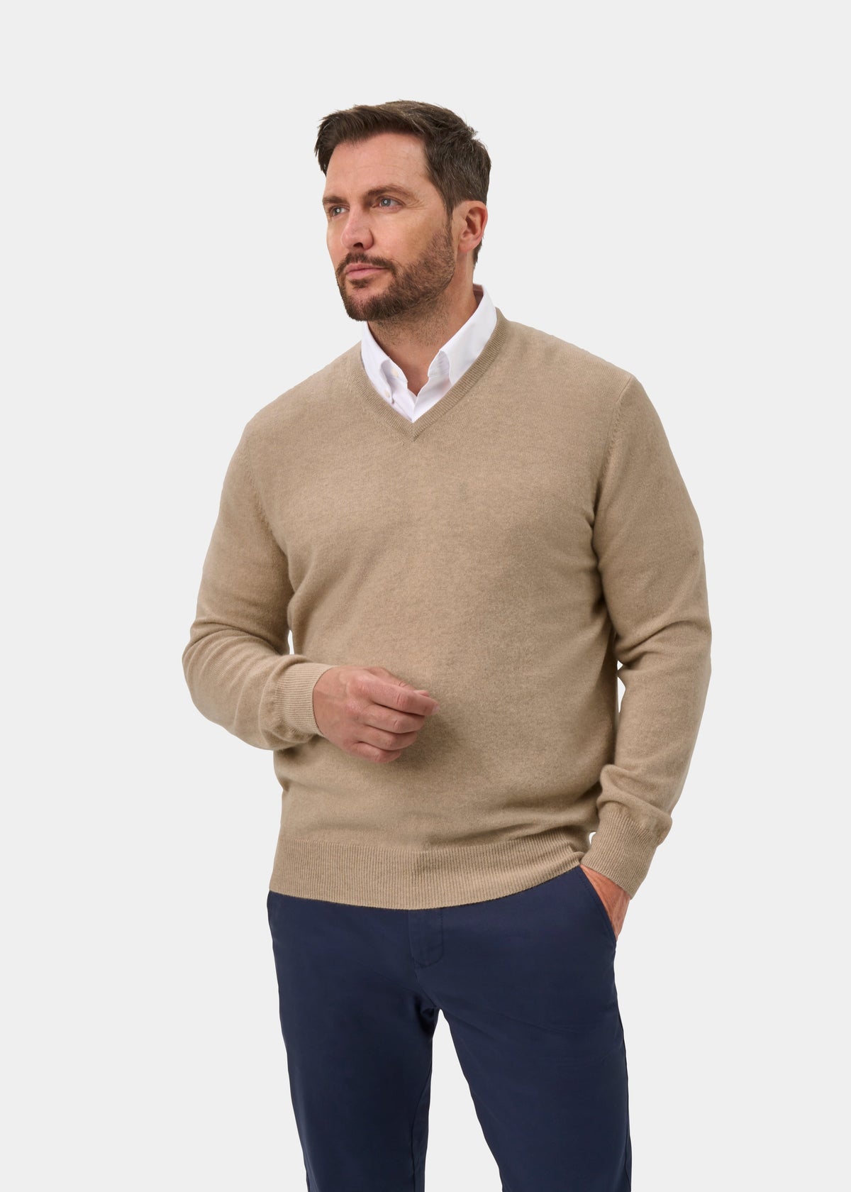 Man in Haddington Pure Cashmere V-Neck Jumper in Linen, white shirt, navy pants, on a plain white background.