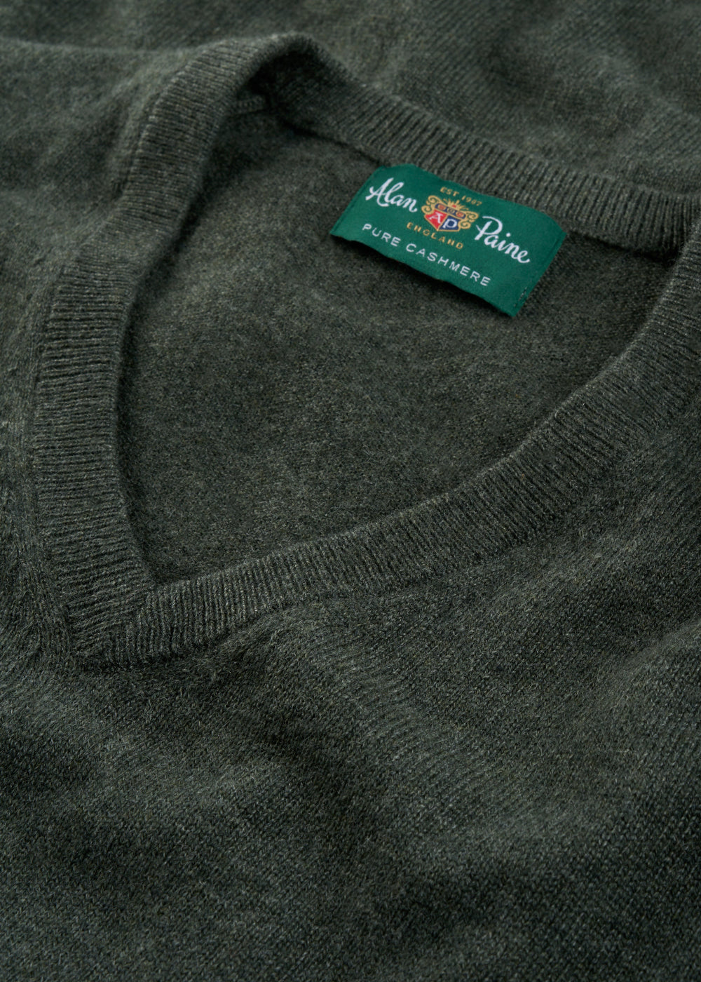 Close-up of the Haddington Pure Cashmere V-Neck Jumper in Rosemary, regular fit, featuring its branded label.