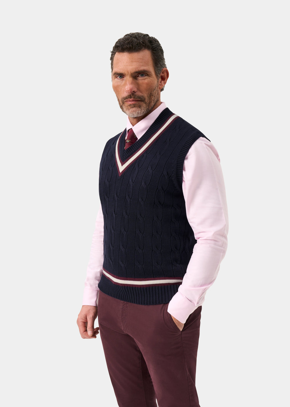 Man in Chadbury cotton cable knit V-neck cricket slipover in Dark Navy and Blackcurrant over a pink shirt and tie.