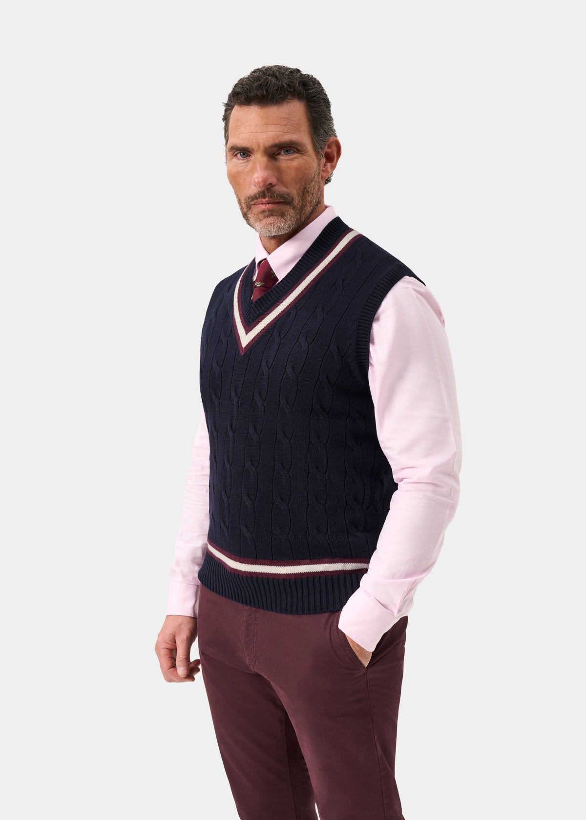 Man in Chadbury cotton cable knit V-neck cricket slipover in Dark Navy and Blackcurrant over a pink shirt and tie.