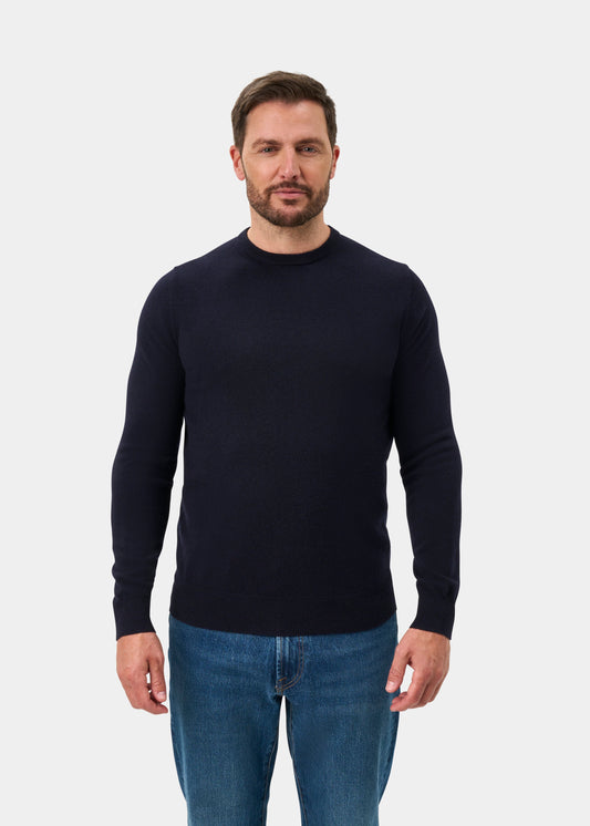 Man facing forward in Brisbane Geelong Wool Crew Neck Jumper in Dark Navy, regular fit, and blue jeans on white background.