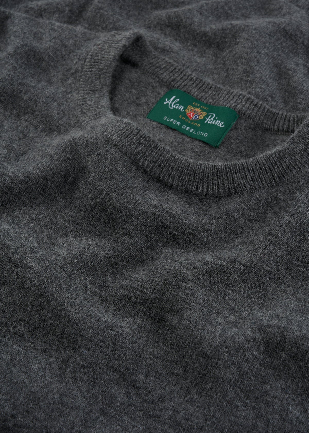 Close-up of a gray Brisbane Geelong Wool Crew Neck Jumper in Derby, regular fit, with green Alan Paine label.