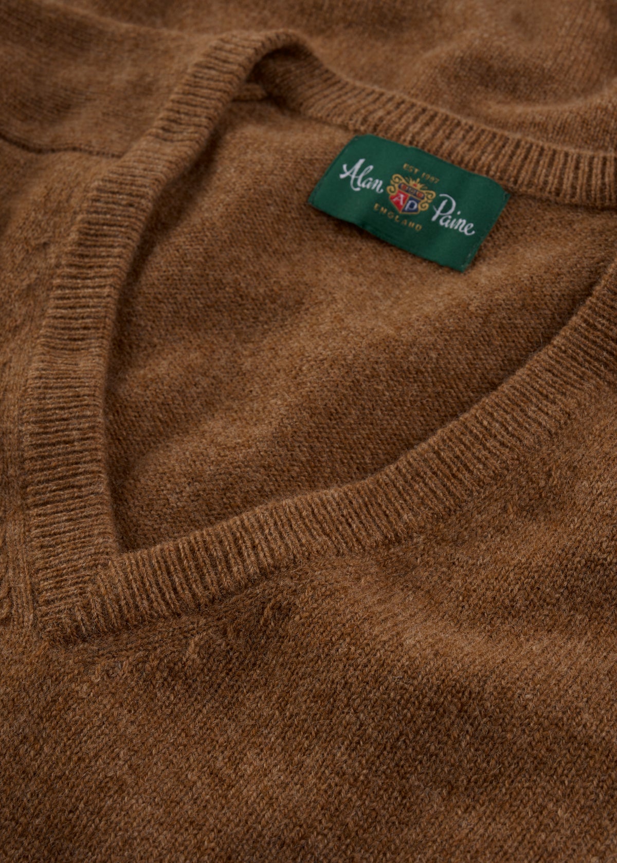 Close-up of the Hampshire Lambswool Vee Neck Jumper in Driftwood, classic fit, with a visible Alan Paine label.