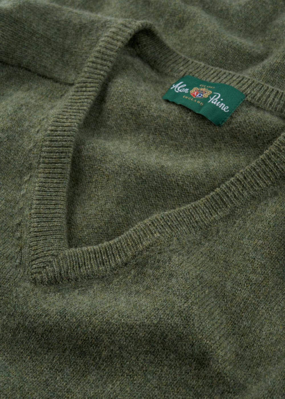 Close-up of the Kilsyth Lambswool V-Neck Jumper in Landscape, folded with an Alan Paine, England label.