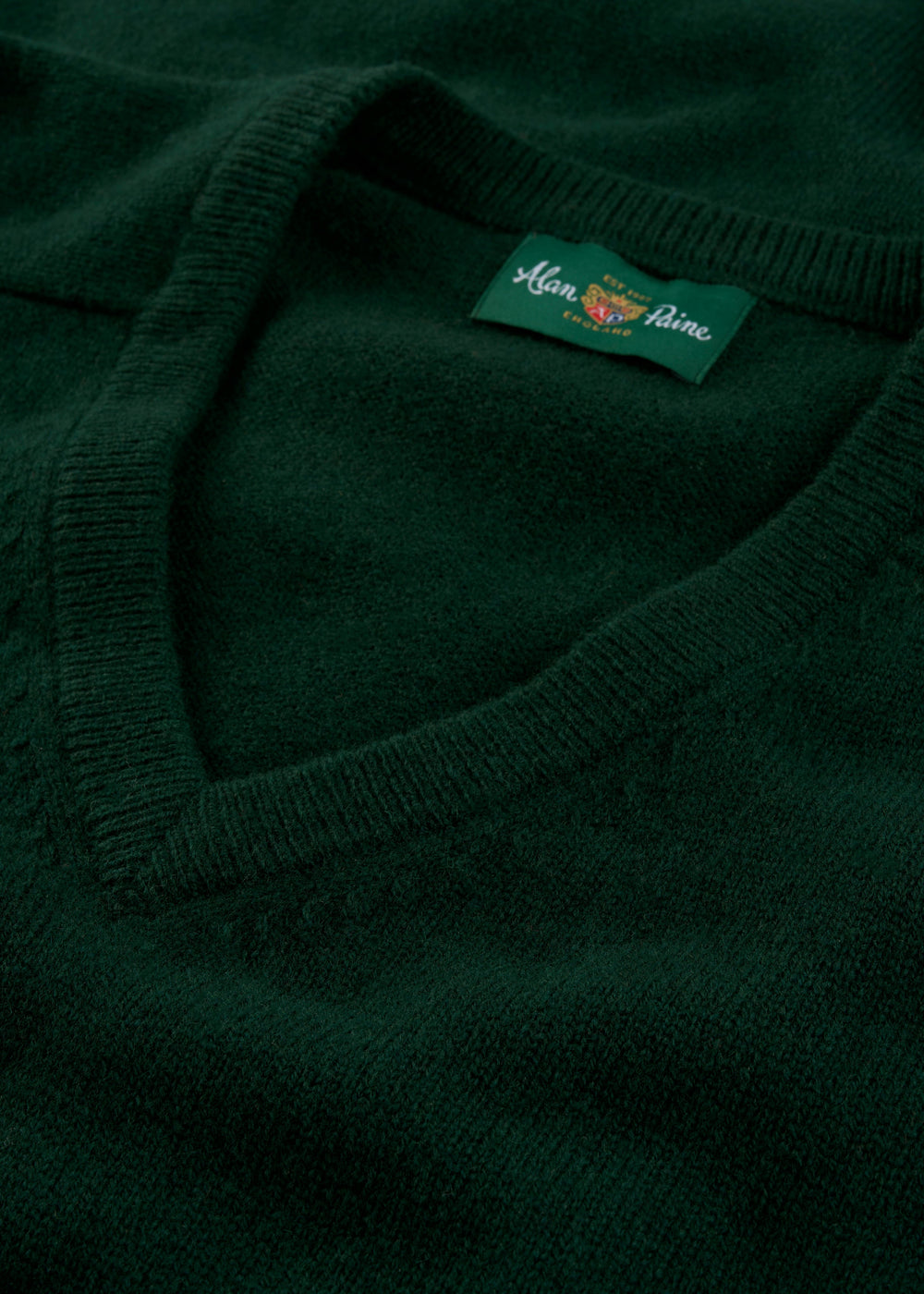 Close-up of Kilsyth Lambswool V-Neck Jumper in Tartan Green, regular fit, with Alan Paine label on collar.