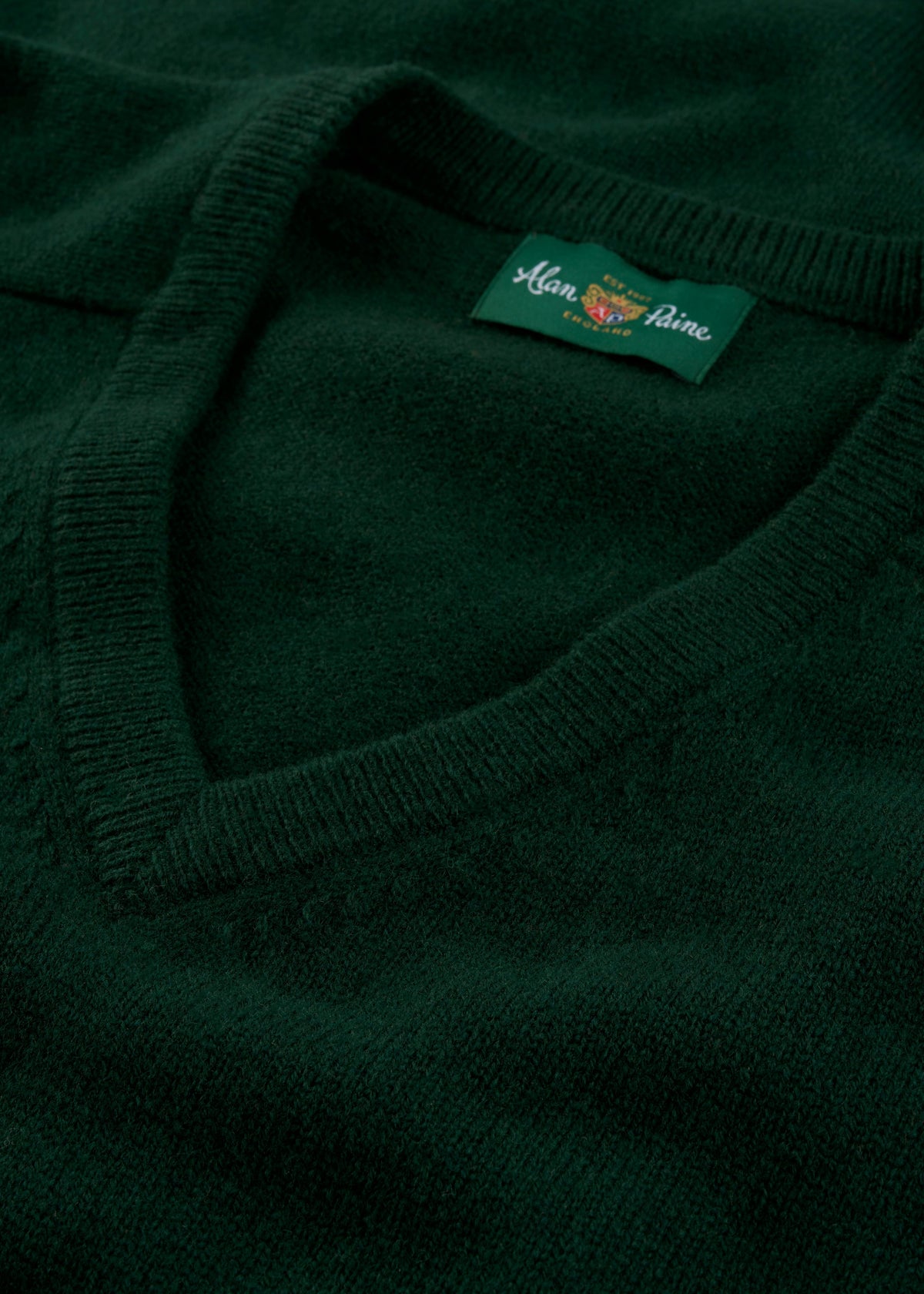 Close-up of Kilsyth Lambswool V-Neck Jumper in Tartan Green, regular fit, with Alan Paine label on collar.