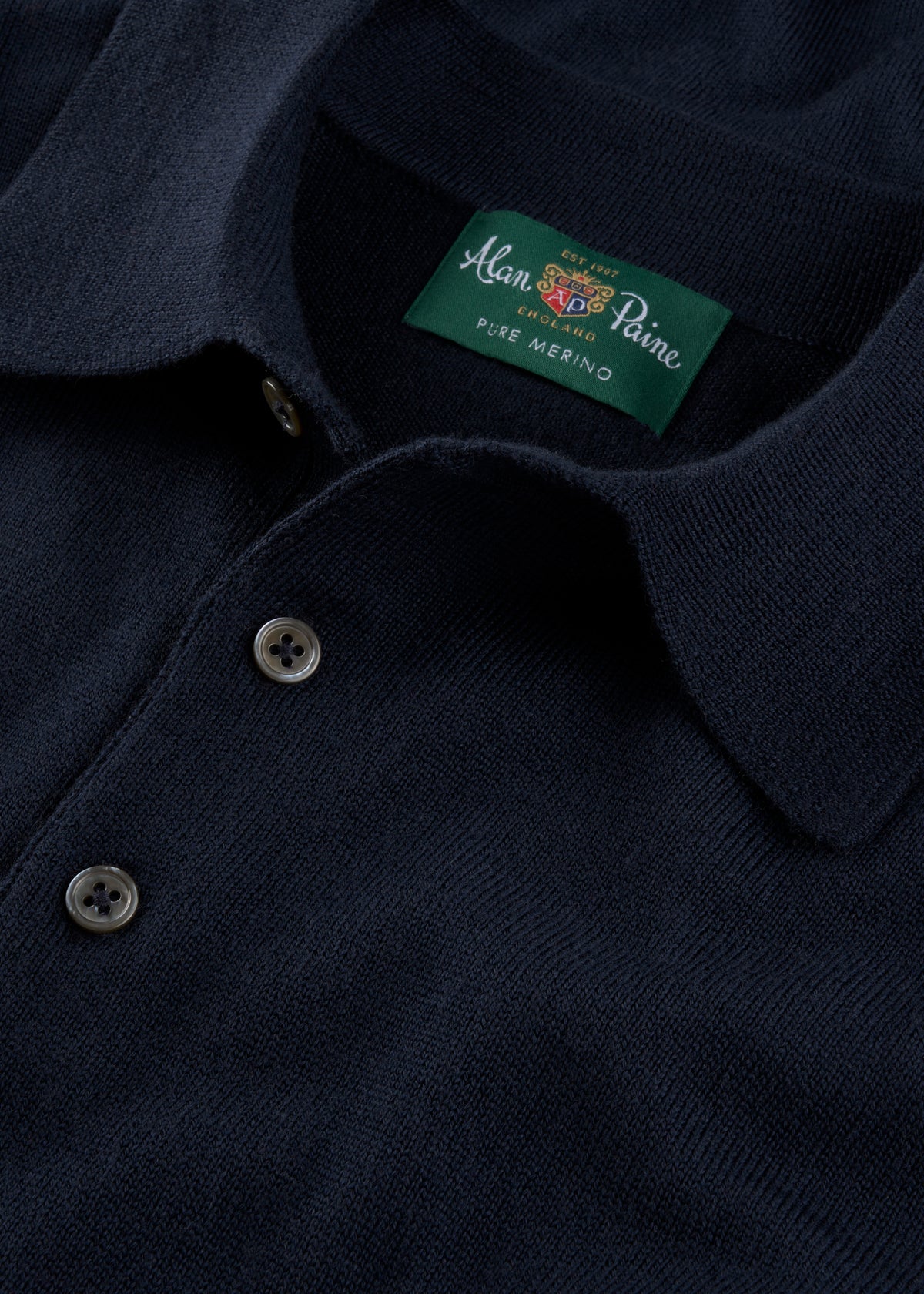 Hindhead Men’s Merino Wool Polo Shirt in Dark Navy, regular fit, long sleeve with buttons and green Alan Paine label.