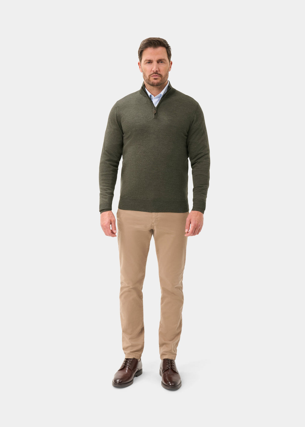 Man wears Barton Merino Wool Quarter Zip Jumper in Seaweed, khaki pants, and brown shoes against a white background.