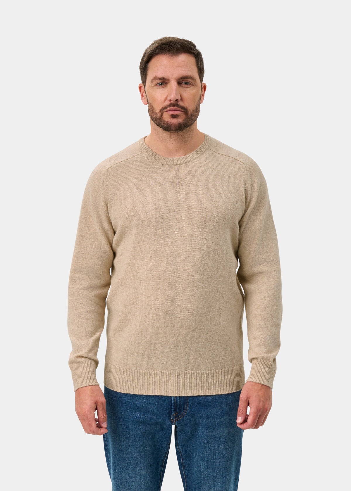 Model wears Dorset Lambswool Crew Neck Jumper in Linen, Classic Fit, with blue jeans against a plain white background.