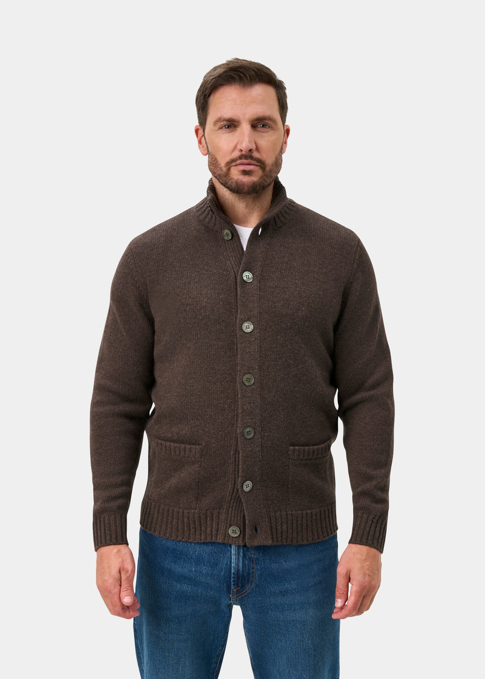 Man wearing a mocha Landford Lambswool buttoned mock neck jumper and blue jeans, against a white background.
